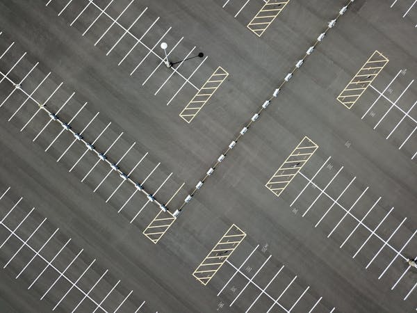 Aerial view of an empty parking lot with crisp white lines and markings