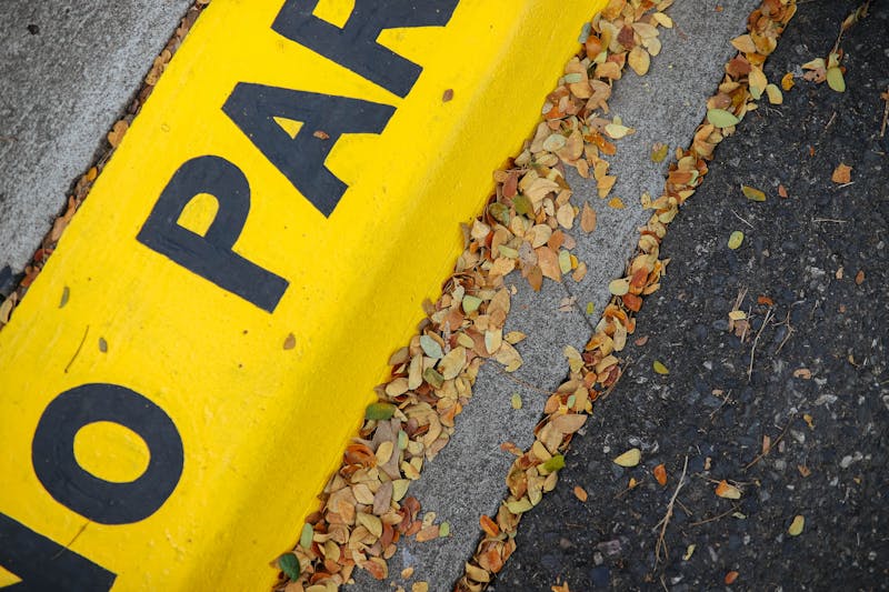 Yellow painted curb with No Parking stencil text