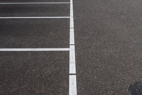 Close-up of fresh crisp white parking lot lines on dark asphalt