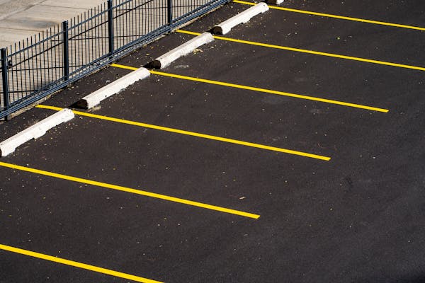 Fresh yellow parking lot lines on clean black asphalt